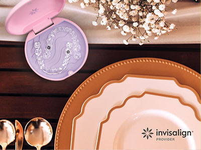 A photograph of a dining table with various plates and cutlery set on it, accompanied by a purple box that appears to contain a dental product.