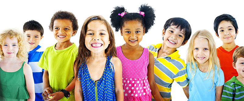 A diverse group of children and a few adults, all smiling broadly at the camera.