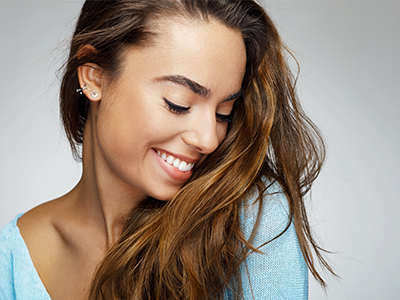 The image features a woman with long hair, smiling gently at the camera.