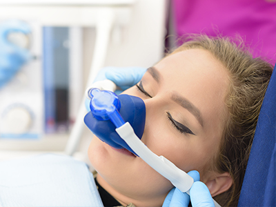 The image shows a person receiving medical treatment, likely in a hospital setting, with the assistance of a healthcare professional using specialized equipment.